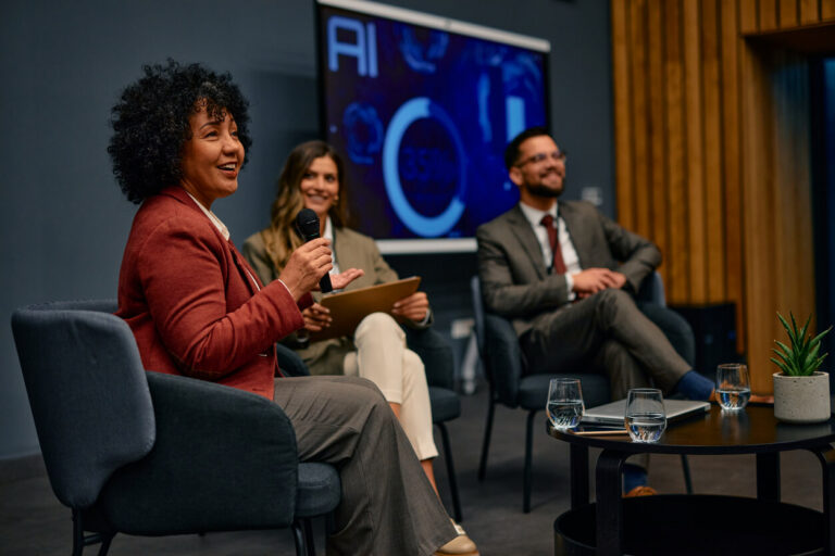 Diverse group of business professionals listening attentively as a businesswoman leads a discussion